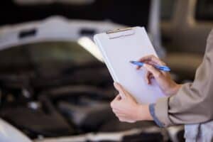 Female mechanic preparing a check list at the repair garage
