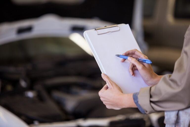 Female mechanic preparing a check list at the repair garage